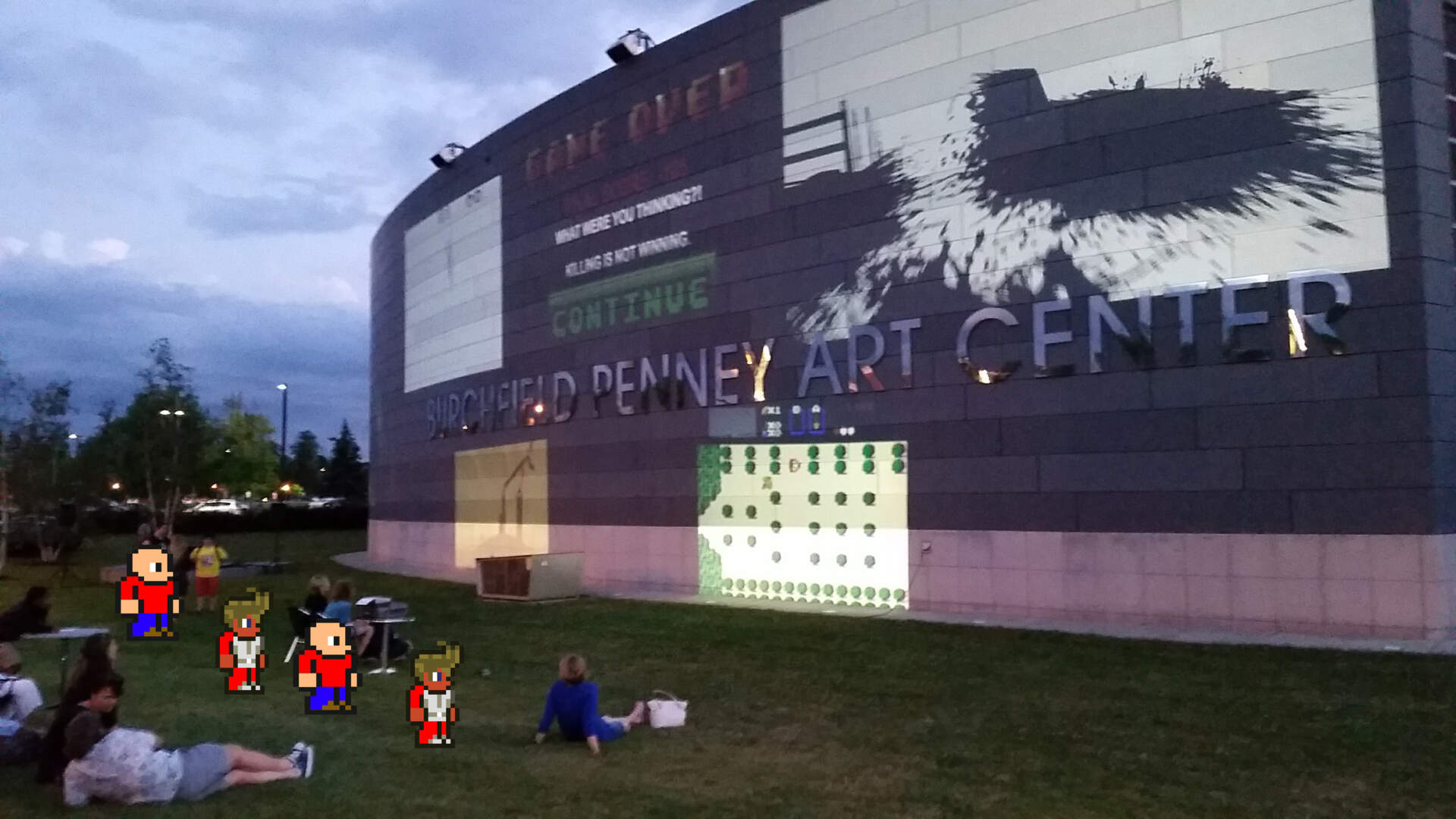 Humans and pixel creatures in the Front Yard for video game night