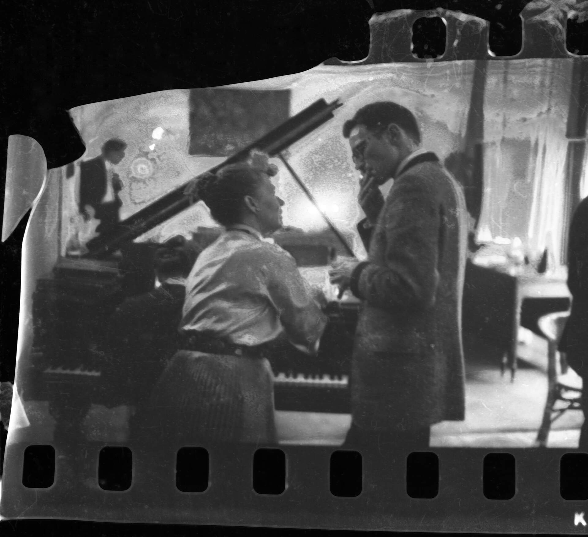 Untitled photographic negative (Virginia talking with man at piano)