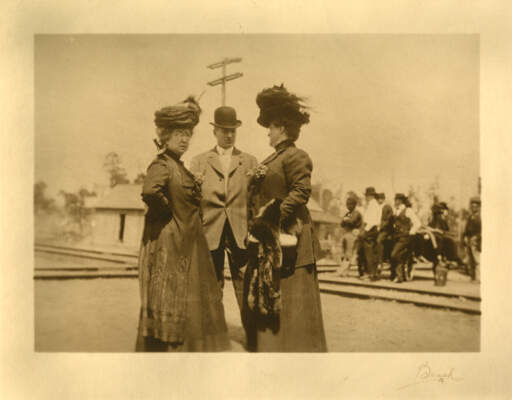 Untitled [a man between two women at a train crossing]